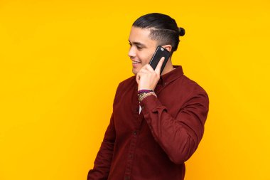 Asyalı yakışıklı adam sarı arka planda izole edildi.