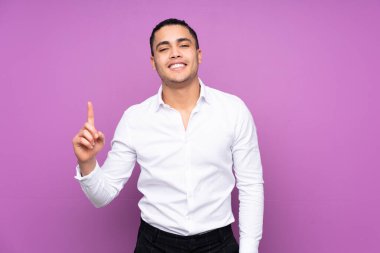 Asyalı yakışıklı adam mavi arka planda izole edilmiş harika bir fikre işaret ediyor.