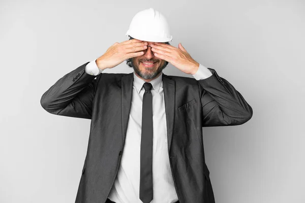 Jovem Arquiteto Homem Com Capacete Sobre Fundo Isolado Cobrindo Olhos — Fotografia de Stock