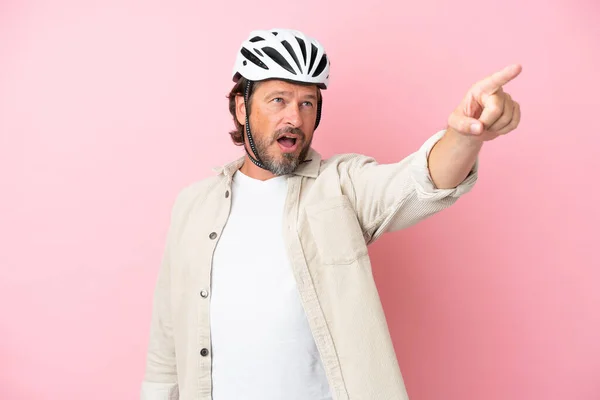 Homem Holandês Sênior Com Capacete Bicicleta Isolado Fundo Rosa Apontando — Fotografia de Stock