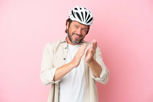 在一个会议上 戴着粉色背景隔离自行车头盔的高个子男人在演讲后欢呼 — 图库照片