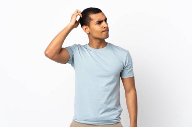 Kafasını kaşıyan Afrikalı Amerikalı bir adam beyaz arka planda kuşkuları var.