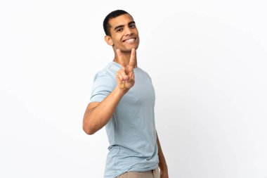 İzole edilmiş beyaz arka plan üzerinde gülümseyen ve zafer işareti gösteren Afrikalı Amerikalı bir adam.