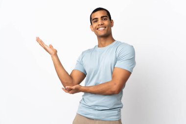 İzole edilmiş beyaz arka planda yaşayan Afrikalı Amerikalı adam davet edildiği için ellerini yana uzatıyor.