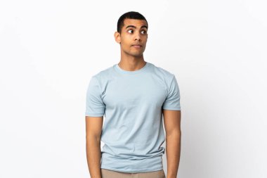 Beyaz arka planda kalan Afro-Amerikalı adam şüpheli hareketler yapıyor.