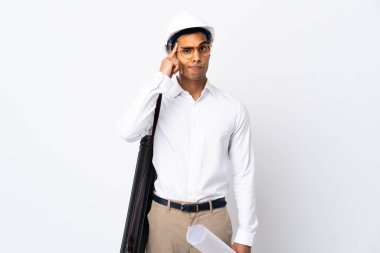 Kafasında miğferi olan ve izole edilmiş beyaz arkaplan üzerinde planları olan Afrikalı Amerikalı mimar bir fikir üretiyor.