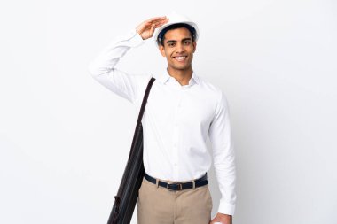 Miğferli Afrikalı Amerikalı mimar ve izole edilmiş beyaz arkaplan üzerinde planları olan mutlu bir ifadeyle selamlıyor.