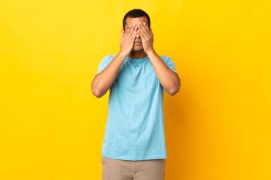 Tecrit edilmiş arka planda yaşayan Afro-Amerikalı adam elleriyle gözlerini kapatıyor