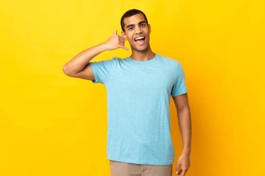 Afrika kökenli Amerikalı bir adam telefon jesti yapıyor. Bana geri dönüş işareti ver.