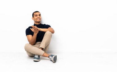 Afro-Amerikalı adam bir konferansta sunumdan sonra alkışlıyor.