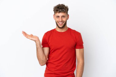 Beyaz arka planda izole edilmiş beyaz tenli yakışıklı bir adam, bir ilan vermek için avucunda hayali bir fotokopi makinesi tutuyor.