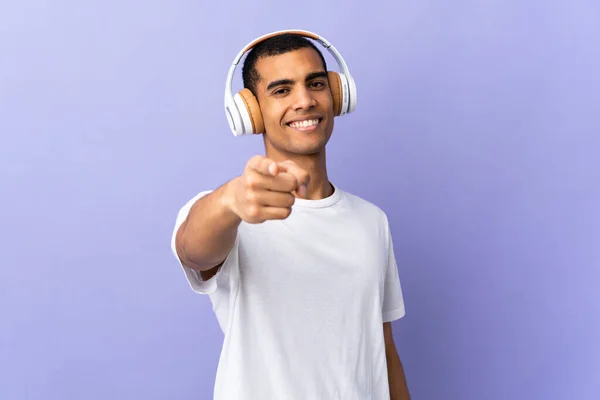 Afro Amerikaanse Man Geïsoleerde Paarse Achtergrond Luisteren Muziek Wijzen Naar — Stockfoto