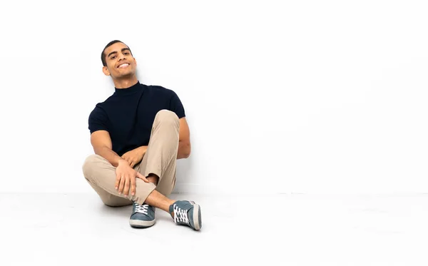 Afroamerikaner Sitzt Auf Dem Boden Und Posiert Mit Den Armen — Stockfoto
