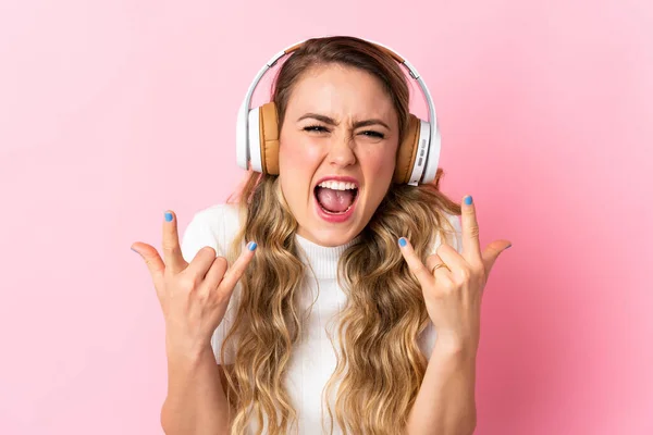 Νεαρή Βραζιλιάνα Απομονωμένη Ροζ Φόντο Ακούγοντας Μουσική Κάνοντας Ροκ Χειρονομία — Φωτογραφία Αρχείου