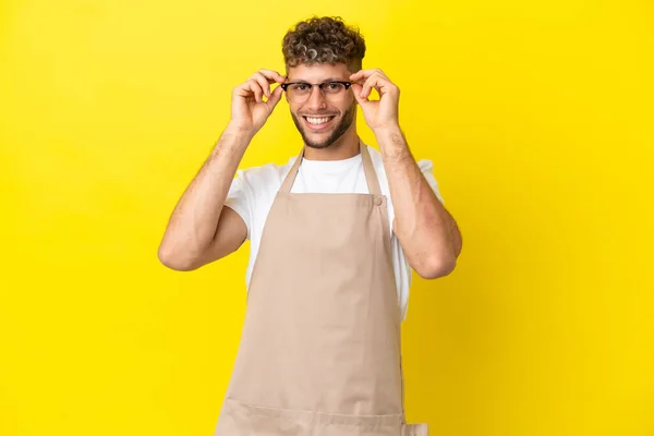 Restaurante Garçom Loiro Homem Isolado Fundo Amarelo Com Óculos Surpreso — Fotografia de Stock