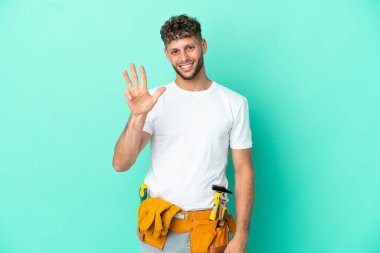 Genç elektrikçi sarışın adam yeşil arka planda izole edilmiş mutlu ve parmakları olan dört kişi sayıyor.