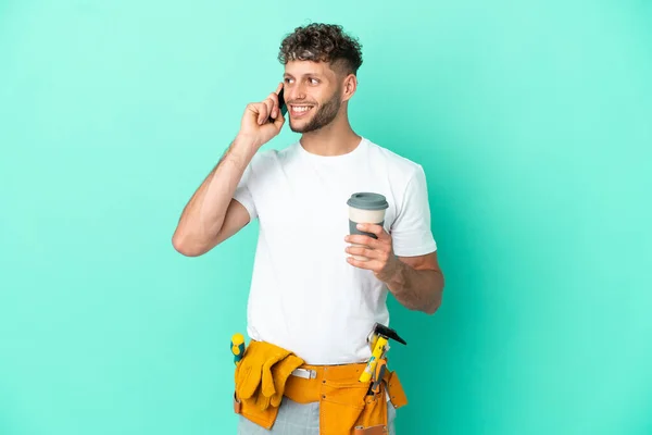 Νεαρός Ηλεκτρολόγος Ξανθός Άνδρας Απομονωμένος Πράσινο Φόντο Κρατώντας Καφέ Για — Φωτογραφία Αρχείου