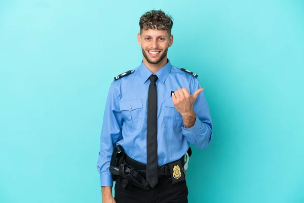 Joven Policía Rubia Hombre Aislado Blanco Sobre Fondo Azul Apuntando —  Fotos de Stock