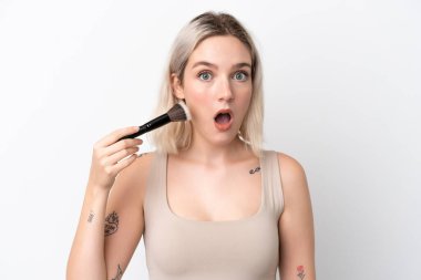 Beyaz arka planda izole edilmiş, elinde makyaj fırçası olan beyaz bir kadın.