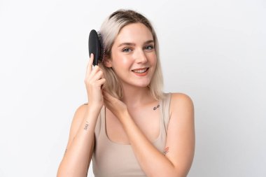 Beyaz arka planda saç tarağıyla izole edilmiş beyaz bir beyaz kadın.