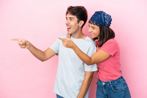 Jong Paar Geïsoleerd Roze Achtergrond Presenteren Van Een Idee Terwijl — Stockfoto