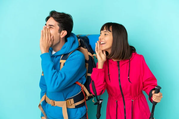 Pareja Jóvenes Montañeros Aislados Sobre Fondo Azul Gritando Con Boca —  Fotos de Stock