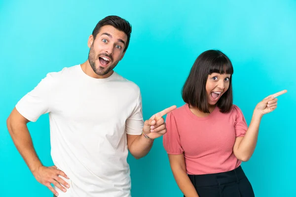 Junges Paar Isoliert Auf Blauem Hintergrund Zeigt Mit Dem Finger — Stockfoto