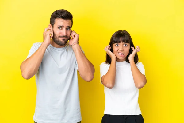 Junges Paar Isoliert Auf Gelbem Hintergrund Beide Ohren Mit Händen — Stockfoto