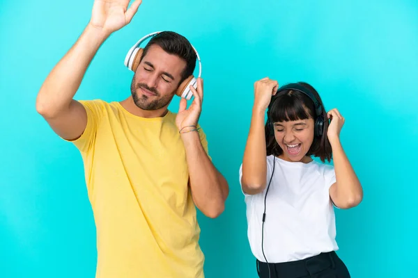 Νεαρό Ζευγάρι Απομονωμένο Μπλε Φόντο Ακούγοντας Μουσική Και Χορεύοντας — Φωτογραφία Αρχείου