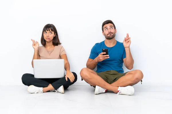 Jovem Casal Sentado Chão Segurando Telefone Celular Isolado Fundo Branco — Fotografia de Stock