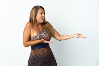 Orta yaşlı Brezilyalı kadın, yalıtılmış arka planda sürpriz bir ifadeyle yan yana bakarken