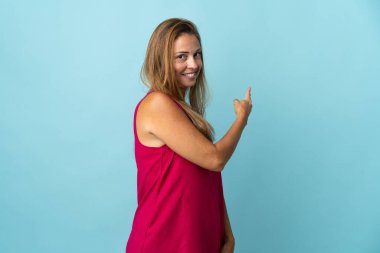 Mavi arka planda izole edilmiş orta yaşlı Brezilyalı kadın