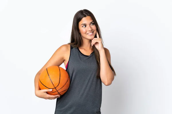 年轻的巴西女子在打篮球时 背景是白色的 一边举目一边思考着一个想法 — 图库照片