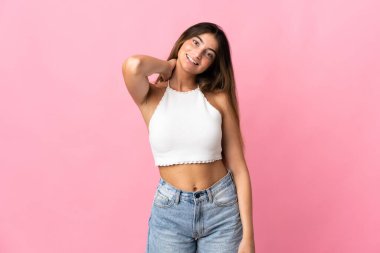 Pembe arka planda izole edilmiş genç beyaz kadın gülüyor.