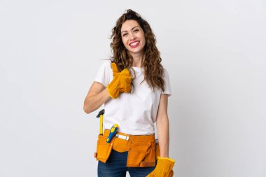 Genç elektrikçi beyaz arka planda izole edilmiş bir şekilde baş parmak hareketi yapıyor.