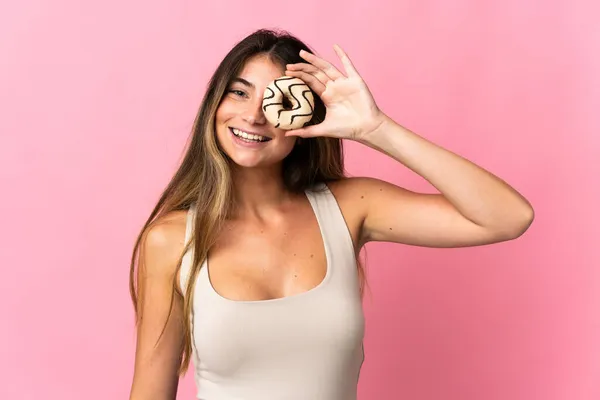 Νεαρή Λευκή Γυναίκα Απομονωμένη Ροζ Φόντο Κρατώντας Ένα Ντόνατ Και — Φωτογραφία Αρχείου