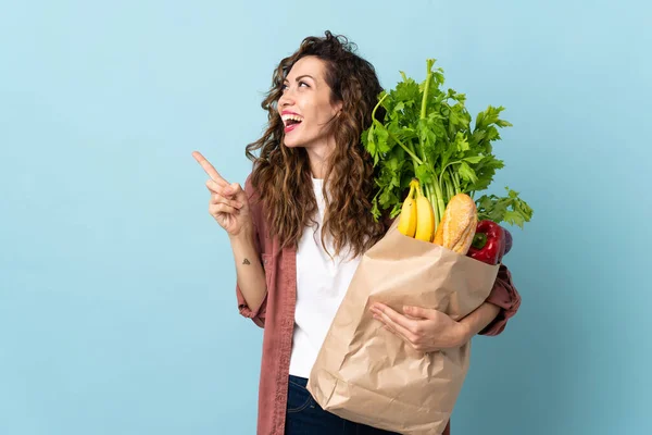 Giovane Donna Che Tiene Sacchetto Della Spesa Isolato Sfondo Blu — Foto Stock