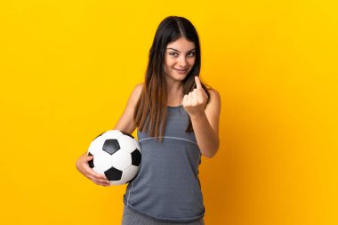 Genç futbolcu kadın sarı arka planda izole edilmiş bir şekilde geliyor.