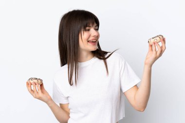 Genç Ukraynalı bir kadın beyaz arka planda izole edilmiş elinde mutlu bir ifadeyle donut tutuyor.