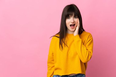 Genç Ukraynalı bir kadın pembe arka planda izole edilmiş, şaşırmış ve şok olmuş bir yüz ifadesi var.