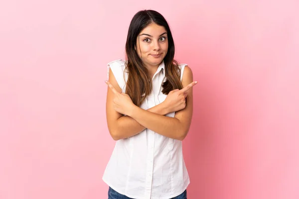 Mujer Joven Caucásica Aislada Sobre Fondo Rosa Apuntando Los Laterales —  Fotos de Stock