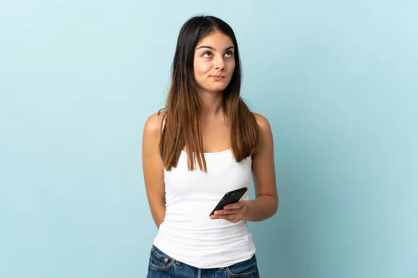 Junge Kaukasische Frau Benutzt Handy Isoliert Auf Blauem Hintergrund Und — Stockfoto