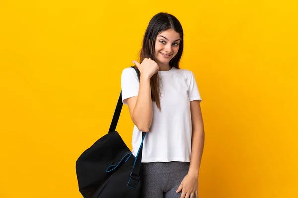 Jovem Mulher Desportiva Com Saco Desportivo Isolado Fundo Amarelo Apontando — Fotografia de Stock