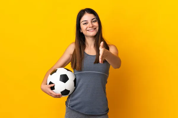 若いですサッカー選手女性孤立しました上の黄色の背景揺れ手のために閉じますA良い取引 — ストック写真