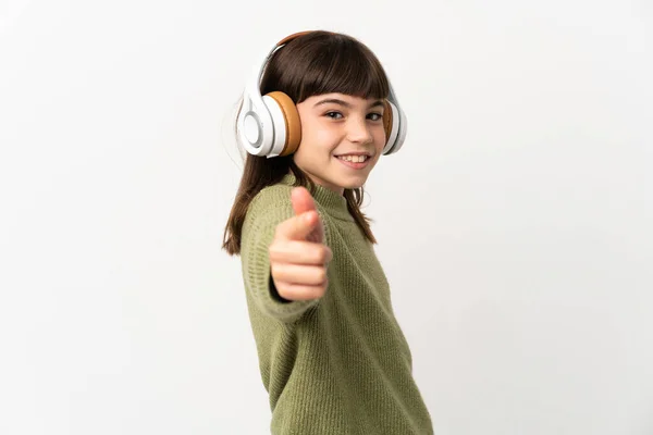 小さな女の子リスニング音楽とともにモバイル隔離されたオンホワイトバックリスニング音楽とフロントを指す — ストック写真