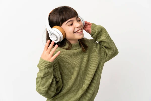 小さな女の子リッスン音楽とともにモバイル隔離されたオンホワイトバックリスニング音楽と歌 — ストック写真