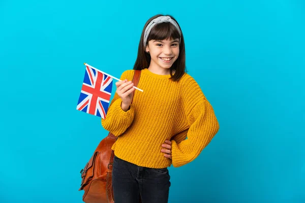 在蓝色背景下学习英语的小女孩 双手叉腰 面带微笑 — 图库照片