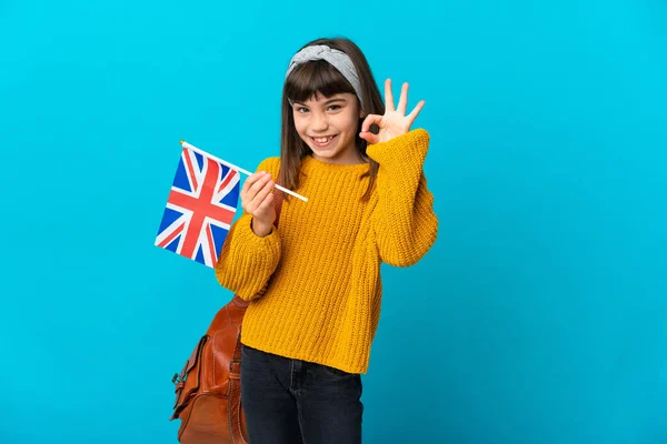 在蓝色背景下学习英语的小女孩用手指示意 — 图库照片