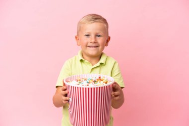 Küçük Rus çocuk izole bir arka planda büyük bir kasede patlamış mısır yiyor.