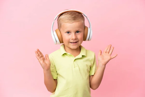 俄罗斯小男孩被粉色背景隔离 一边用手机一边听音乐 一边唱歌 — 图库照片
